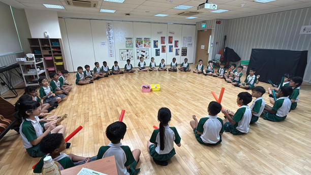 Students seated in a circle during a classroom music learning activity.